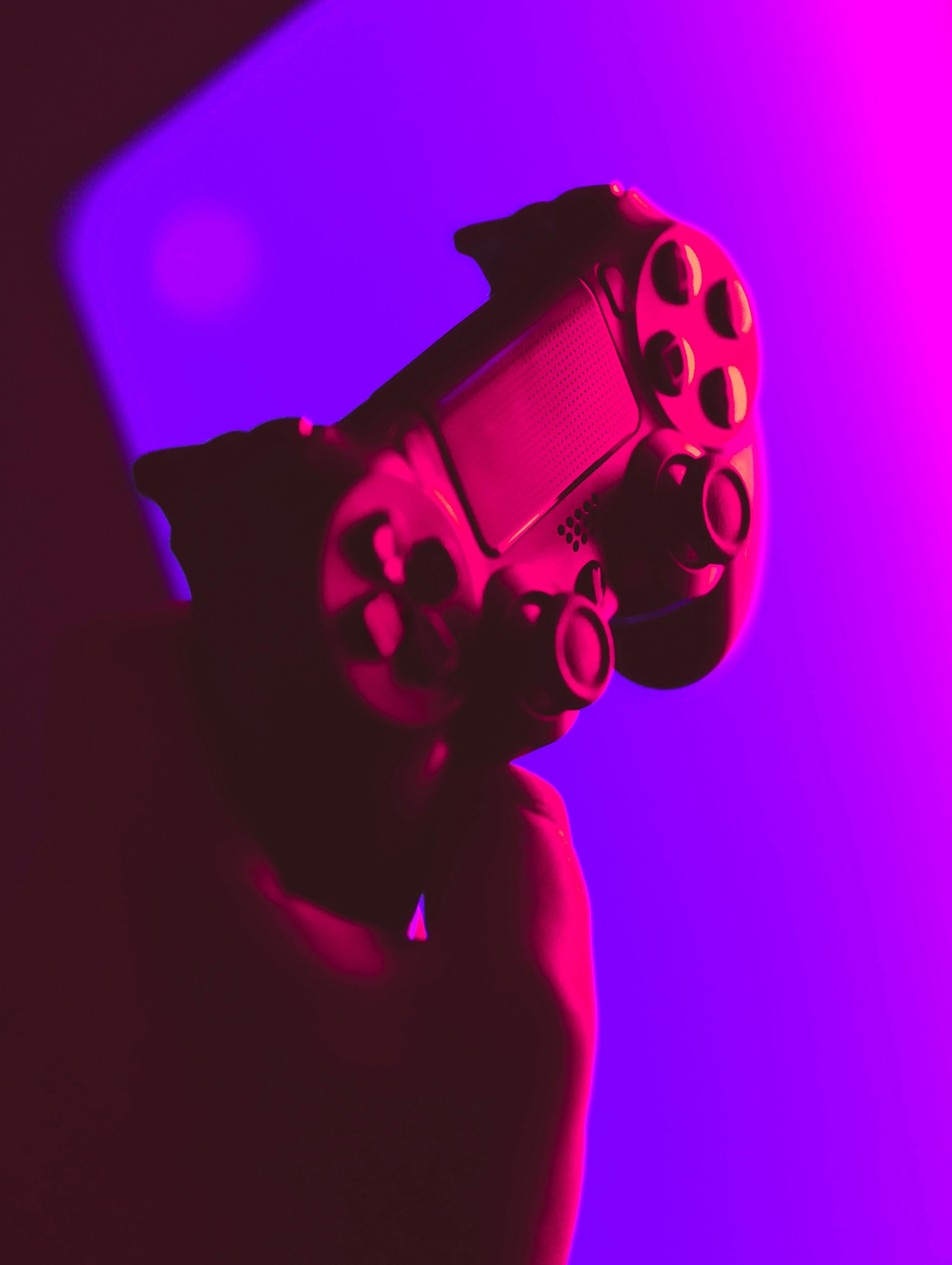 Spielkonsolen Controller in rotem Licht mit Lila Hintergrund